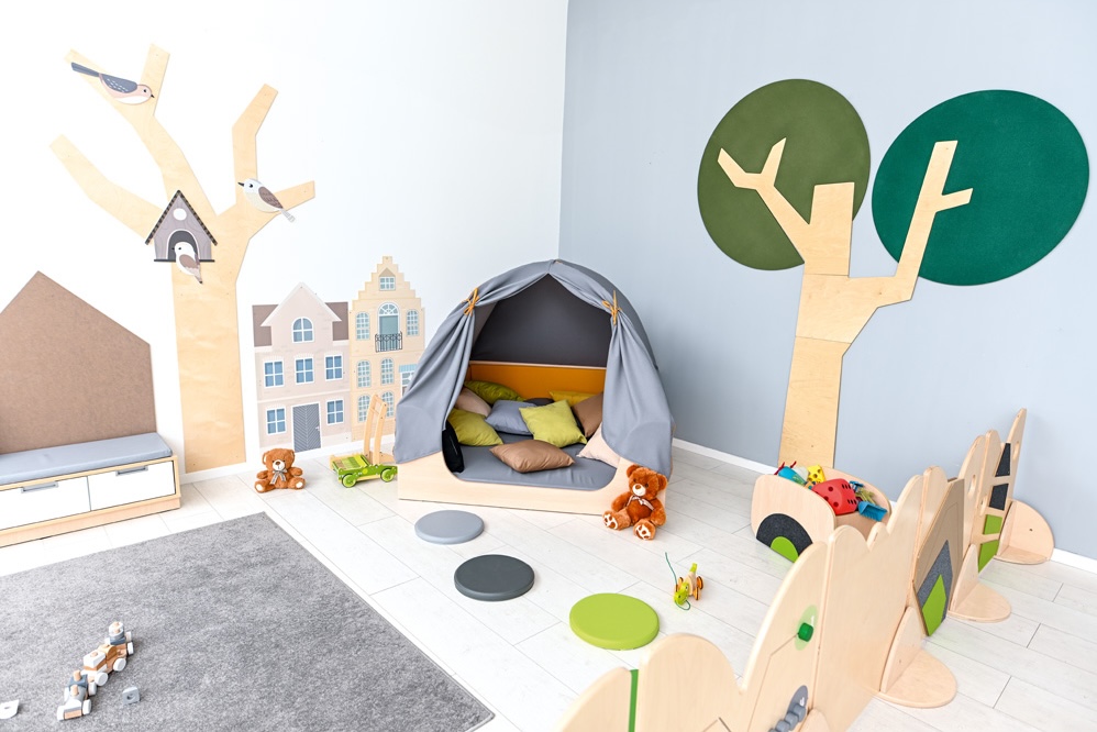 Aménagement d'un coin calme dans une salle de classe avec une cabane pour enfant et des coussins